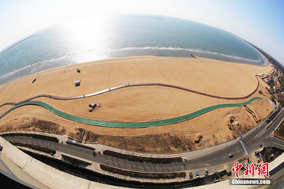 3月13日，秦皇島萬米臨海沙灘木棧道。據了解，該木棧道全長約4200米，與北戴河區(qū)原有的7500米木棧道對接后全線總長度1.17萬米，整個木棧道東起秦皇島體育基地游船碼頭，西至北戴河濕地公園，呈波浪形蜿蜒10.4公里海岸線。 中新社發(fā) 曹建雄 攝 CNSPHOTO